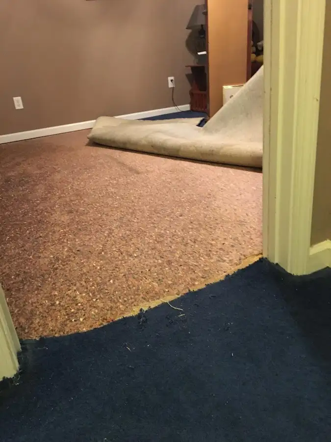 Carpet pad removal revealing water damage during Drying & Dehumidification in Crete